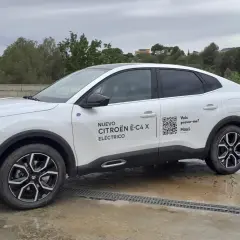 Citroën ë-C4 X eléctrico blanco aparcado en un día nublado. El coche tiene un diseño moderno y elegante.