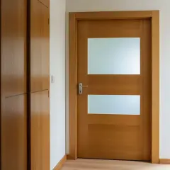 Jak przerobić stare drzwi z szybą na nowoczesne? Drewniane drzwi z dwoma matowymi przeszkleniami i eleganckim uchwytem.