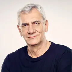 Wiktor Zborowski, z siwymi włosami i w granatowej koszulce, patrzy z uśmiechem w obiektyw.