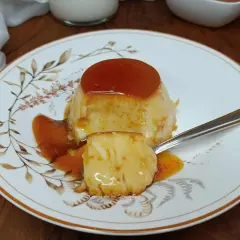 Un delizioso creme caramel, con la sua glassa dorata e la consistenza morbida, pronto per essere gustato.