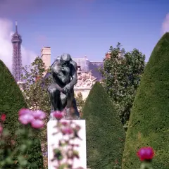 Auguste Rodin Myśliciel w paryskim ogrodzie, z wieżą Eiffla w tle.