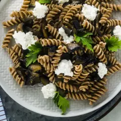 Fusilli integrali con melanzane grigliate, ricotta fresca e prezzemolo. Un piatto estivo leggero e gustoso.