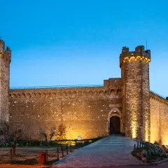 Fortezza illuminata al crepuscolo, un invito a visitare Montalcino e scoprire la sua storia.