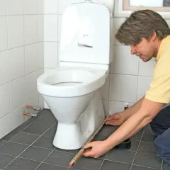 Man mäter för att limma toalettstol.