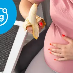 Ciężarna kobieta je banana, symbolizującego magnez w ciąży.