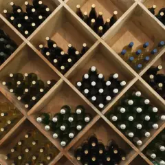 Weinregal mit vielen Flaschen Rotwein und Weißwein. Die Frage, wie lange kann man Rotwein lagern, wird hier durch die Vielfalt der Weine angedeutet.