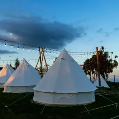 Nocleg w namiotach typu dzwon, oświetlonych girlandami. To właśnie glamping co to – luksusowy kemping w otoczeniu natury.