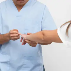Fizjoterapeuta bada palec pacjentki. Gdy masz wybity palec, do jakiego lekarza się udać?
