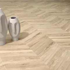 Dwie białe wazony w kształcie twarzy stoją na podłodze z drewnianymi deskami ułożonymi we wzór herringbone.