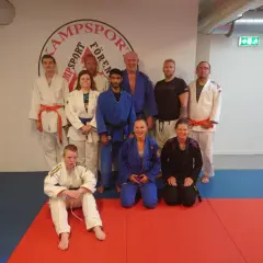 Gruppbild på svenska kampsportare i träningskläder, redo för pass.