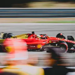Czerwono-żółty bolid Ferrari z numerem 16 pędzi po torze. Zastanawiasz się, ile trwa wyścig F1? To zależy od wielu czynników, ale zawsze jest to ekscytujące widowisko!