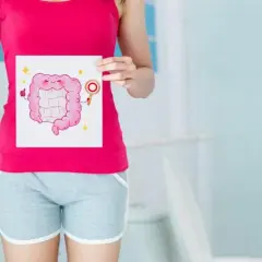 Kobieta pokazuje rysunek uśmiechniętych jelit, sugerując, jak oczyścić jelita. Kciuk w górę i błyszczące gwiazdki podkreślają zdrowie.