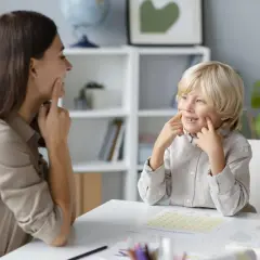 Terapeutka pomaga chłopcu, który nie mówi, ćwiczyć wymowę.