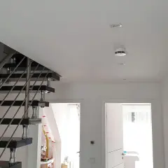 Moderner Flur mit Treppe und einem weißen rauchmelder an der Decke, der für Sicherheit sorgt.