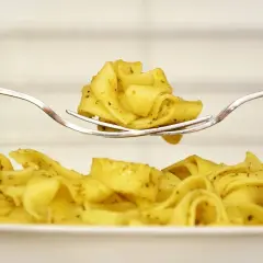 Pyszny makaron tagliatelle na widelcu, idealny pomysł, co zrobić z ugotowanym makaronem.