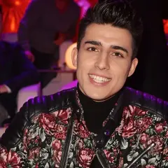 Filip w kwiecistej kurtce, uśmiechnięty. Może to jego żona wybrała mu ten strój na lato?