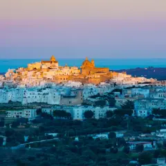 Ostuni, the "White City," glows at sunset, a beautiful destination near the closest airport to Puglia, Italy.