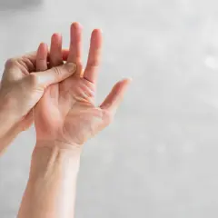 Mani che si massaggiano le dita, un gesto per alleviare il formicolio nel corpo causato dallo stress.