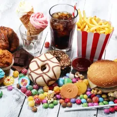 En överflöd av ultraprocessad mat: hamburgare, pommes frites, donuts, godis, glass, läsk och bakverk.