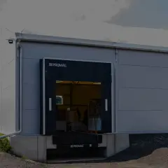 Nowoczesny magazyn z otwartymi dokami przeładunkowymi. Widać rampę i fragment wnętrza z towarami.