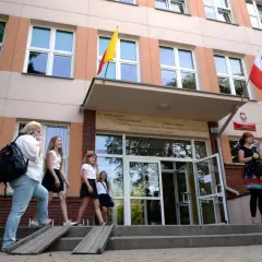 Uczniowie wchodzą do szkoły, przypominając czasy, kiedy powstały gimnazja w Polsce.
