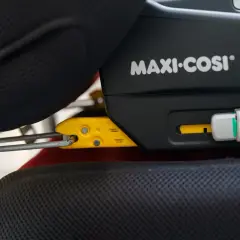 System Isofix co to? Widoczny mechanizm mocowania fotelika samochodowego Maxi-Cosi do siedzenia pojazdu.