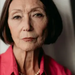 Portret starszej kobiety w różowej koszuli, z naszyjnikiem z pereł. Ewa Woydyłło-Osiatyńska, pierwsza żona, wspomina.