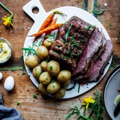 En saftig biff med en härlig kryddig kappa, serverad med småpotatis och morötter. En festmåltid!