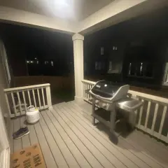 En gasolgrill under taket på altanen, redo för sommarens grillkvällar.
