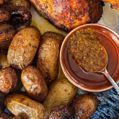 Un plat de poulet portugais rôti avec des pommes de terre dorées et une sauce savoureuse.