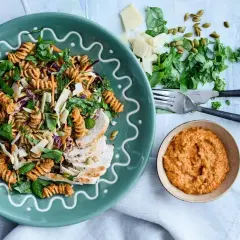 En härlig pastasallad med pesto, kyckling, grönsaker och pumpafrön. Serveras med en extra klick pesto.