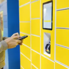 Mężczyzna używa aplikacji InPost Mobile do obsługi paczkomatu.