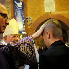 Biskup udziela sakramentu bierzmowania. Zastanawiasz się, ile dać na bierzmowanie? To ważny moment dla młodego człowieka.