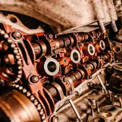 Primer plano de un motor de coche con engranajes y levas, mostrando las piezas de desgaste de un coche.
