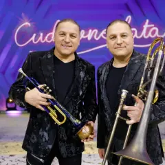 Dwóch muzyków z orkiestry Golec trzyma instrumenty: jeden trąbkę, drugi puzon.