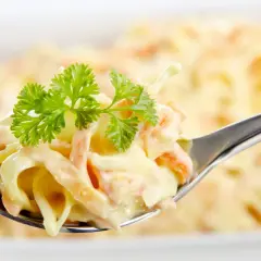 Ein Löffel cremiger Coleslaw Salat, garniert mit Petersilie. Perfekt für ein einfaches coleslaw salat rezept.