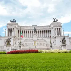 Imponente altare della patria statua equestre al centro, circondato da colonne, bandiere italiane e sculture.