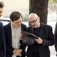 Tomasz Trebacz i kompozytor jazzowy, z kolegami, dyskutują o kapeluszu.
