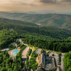 Malowniczy hotel dla dorosłych w górach, otoczony lasem, z basenem i zjeżdżalnią. Idealne miejsce na relaks.