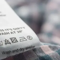 Metka z instrukcją prania: prać w 30°, nie wybielać, prasować w niskiej temperaturze. Materiał zawiera **elastan**, co zapewnia komfort noszenia.
