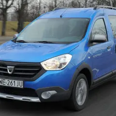 Niebieski Dacia Dokker Stepway w ruchu drogowym.