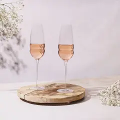 Dwa kieliszki orzeźwiającego wina rose, ozdobione delikatnymi białymi kwiatami, tworzą romantyczną atmosferę.