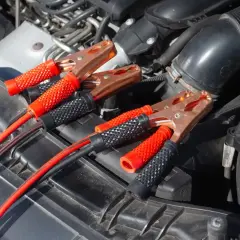 Kable rozruchowe podłączone do akumulatora. Chcesz wiedzieć, jak zwiększyć moc silnika elektrycznego? Sprawdź, jak prawidłowo podłączyć kable.