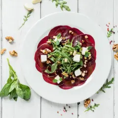 Eleganckie carpaccio z buraka z fetą, orzechami i rukolą. Idealny przepis na lekki i zdrowy posiłek.