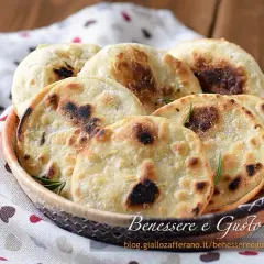 Focaccia senza lievito dorata e fragrante, servita in un cestino, con rosmarino e sale grosso. Perfetta per un pasto veloce e gustoso.