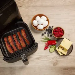 Krispigt bacon i airfryer, redo för en god frukost med ägg, bär och ost.