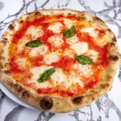 Pyszne ciasto na pizzę neapolitańską z pomidorami, mozzarellą i bazylią. Idealna na letni wieczór.