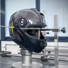 Casco in prova su banco per capire se un casco è omologato. Strumenti di misurazione puntano il guscio in carbonio.