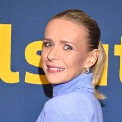 Aneta Zając z uśmiechem pozuje na tle logo. Jej obecny partner pewnie jest dumny z jej sukcesów.