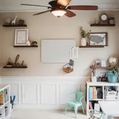 Inspiring modern homeschool room ideas: shelves with decor, a whiteboard, and organized storage create a functional and beautiful learning space.
